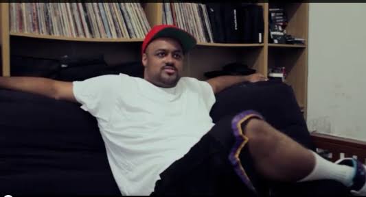 Punch sitting back in a room lined with records, before Top Dawg Entertainment was Top Dawg Entertainment.